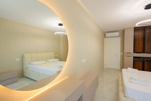 A bedroom with a curved mirror, a bed, a bedside table, and a wardrobe. - Beach Resort Villa with Private Garden (Plazhi San Pietro)
