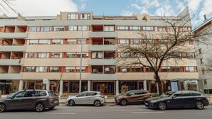 Ein mehrgeschossiges Gebäude im modernen Architekturstil, mit Balkonen und großen Fenstern.