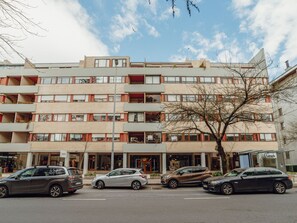 Ein mehrgeschossiges Gebäude im modernen Architekturstil, mit Balkonen und großen Fenstern.