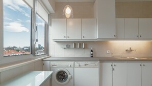 Eine moderne Küche mit Waschmaschine, Spüle und Schränken.