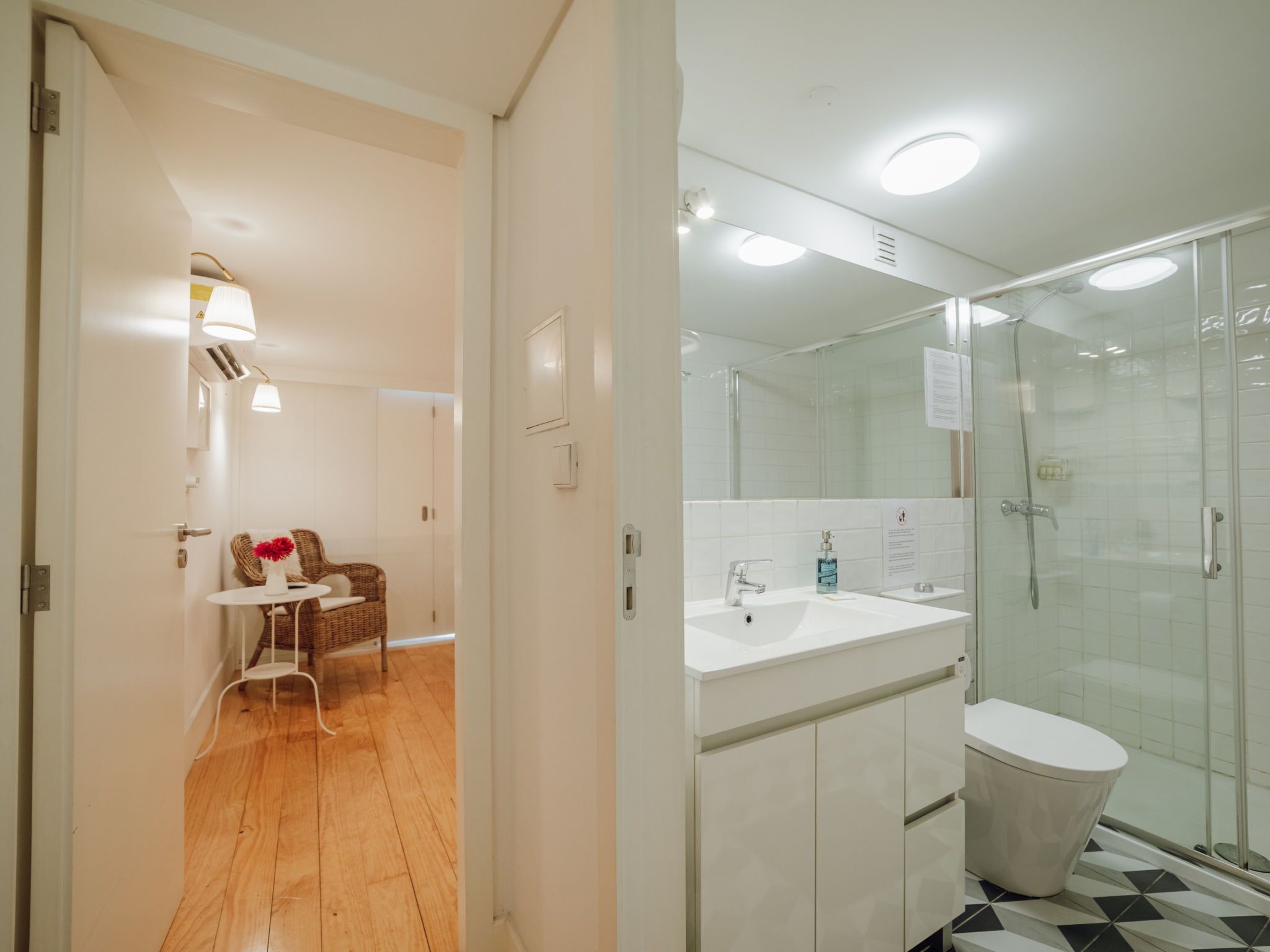 A modern bathroom with a glass shower enclosure, a white sink, and a toilet.