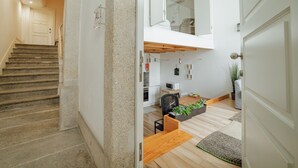 Un interior moderno con una escalera, una zona de cocina y un comedor.