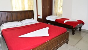 Une chambre d’hôtel avec deux lits, une armoire et un miroir.