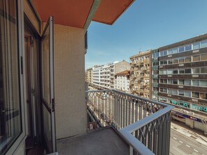 A balcony with a view of a cityscape, featuring modern buildings and a clear sky. - Apartment  by Interhome (Porto)