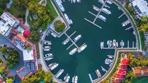 An aerial view of a marina with boats docked, surrounded by buildings and greenery. - Renovated Sea Pines Home Near Beach (Hilton Head Island)