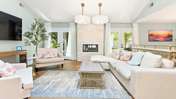 A modern living room with a sectional sofa, a coffee table, a TV, and a fireplace. - Renovated Sea Pines Home Near Beach (Hilton Head Island)