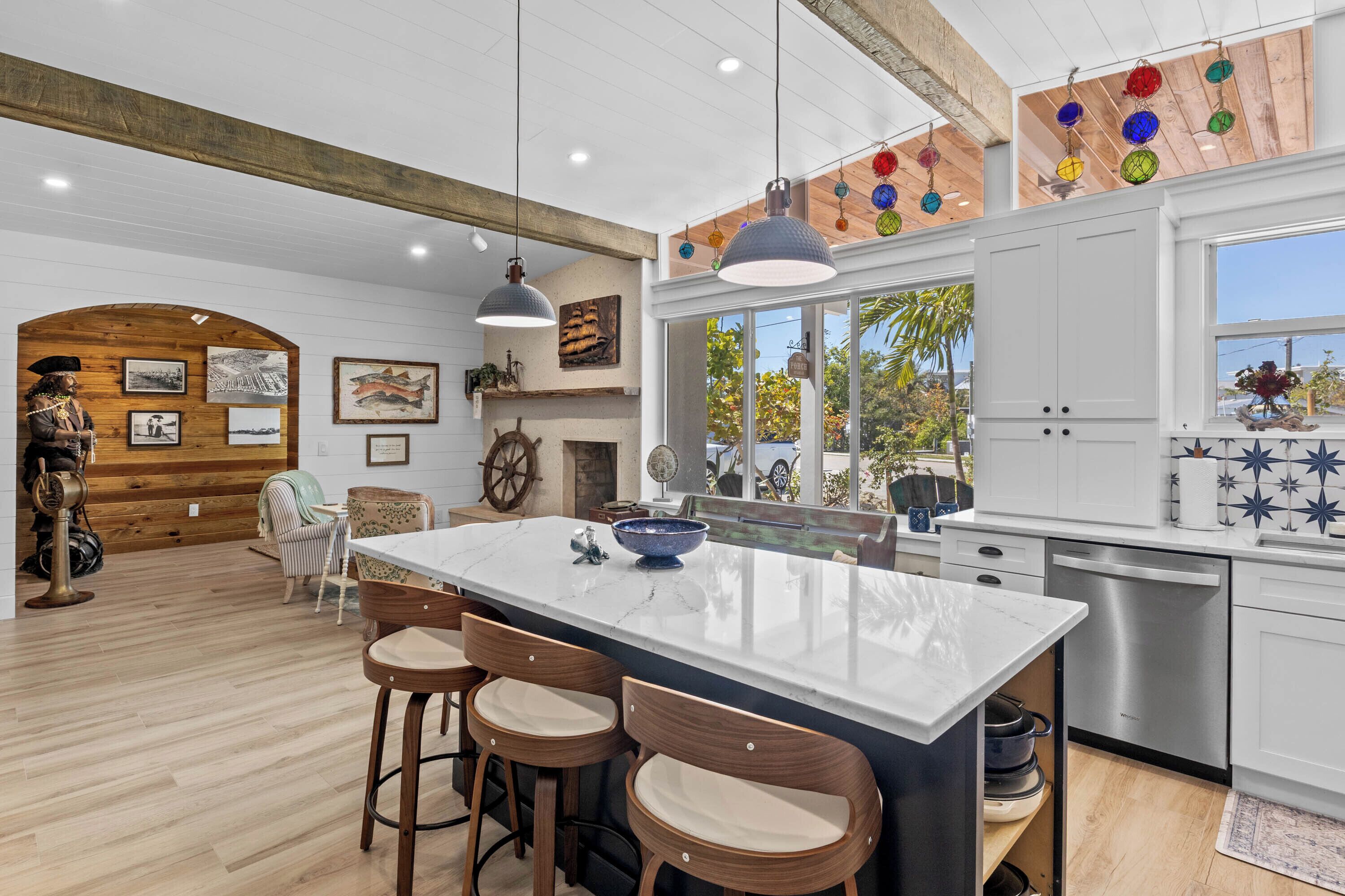 A spacious kitchen with a large island, wooden accents, and a view of the outdoors.