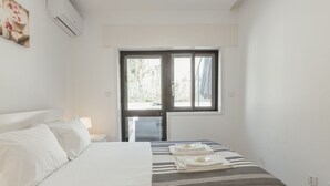Ein Schlafzimmer mit Bett, Fenster und Tür.