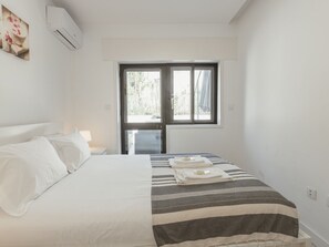 Ein Schlafzimmer mit Bett, Fenster und Tür.