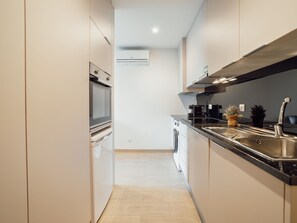 Eine moderne Küche mit Edelstahlgeräten, einem Backofen, einem Geschirrspüler und einer großen Spüle.