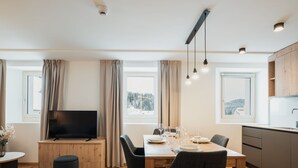 Un espace de vie moderne comprenant un coin repas, une cuisine et un téléviseur.