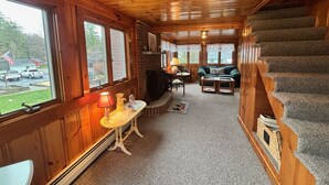 L’intérieur d’une cabane comprend une cheminée, un coin repas, un canapé et un escalier.
