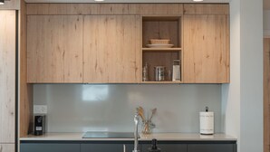 A modern kitchen with wooden cabinets, a stainless steel sink, and a coffee machine. - Alpine Apartments, (San Bernardino), by Interhome (San  Bernardino)