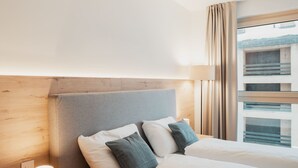 Une chambre d’hôtel avec un lit, une lampe de chevet et une fenêtre avec des rideaux.