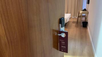 A wooden door with a keycard lock and a sign indicating room service availability.