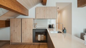 Una cocina moderna con armarios de madera, lavavajillas, un lavamanos y una encimera.