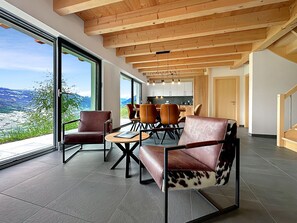 A modern interior with a dining area, large windows, and a view of the outdoors. - My Mountain Paradise in the Swiss Alps by Interhome (Grône-Loye)