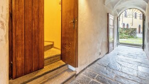 Una escalera de piedra que conduce a una puerta de madera con un aplique arriba.