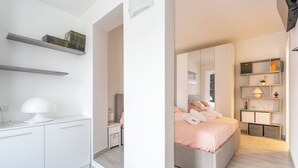 A modern bedroom with a bed, bedside tables, a wardrobe, and built-in shelves. - The Amber - Tremezzo Lake Como (Tremezzo)