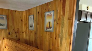 A wooden interior with a bench, patterned rugs, and framed pictures on the wall. - Hayward Riverside Rental (Hayward)
