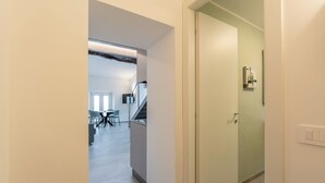 Ein Flur mit Treppe, ein Essbereich mit Stühlen und Tischen sowie eine Tür mit Lichtschalter.