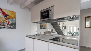 Eine moderne Küche mit Mikrowelle, Spüle aus Edelstahl und einer Treppe, die zu einer anderen Ebene führt.