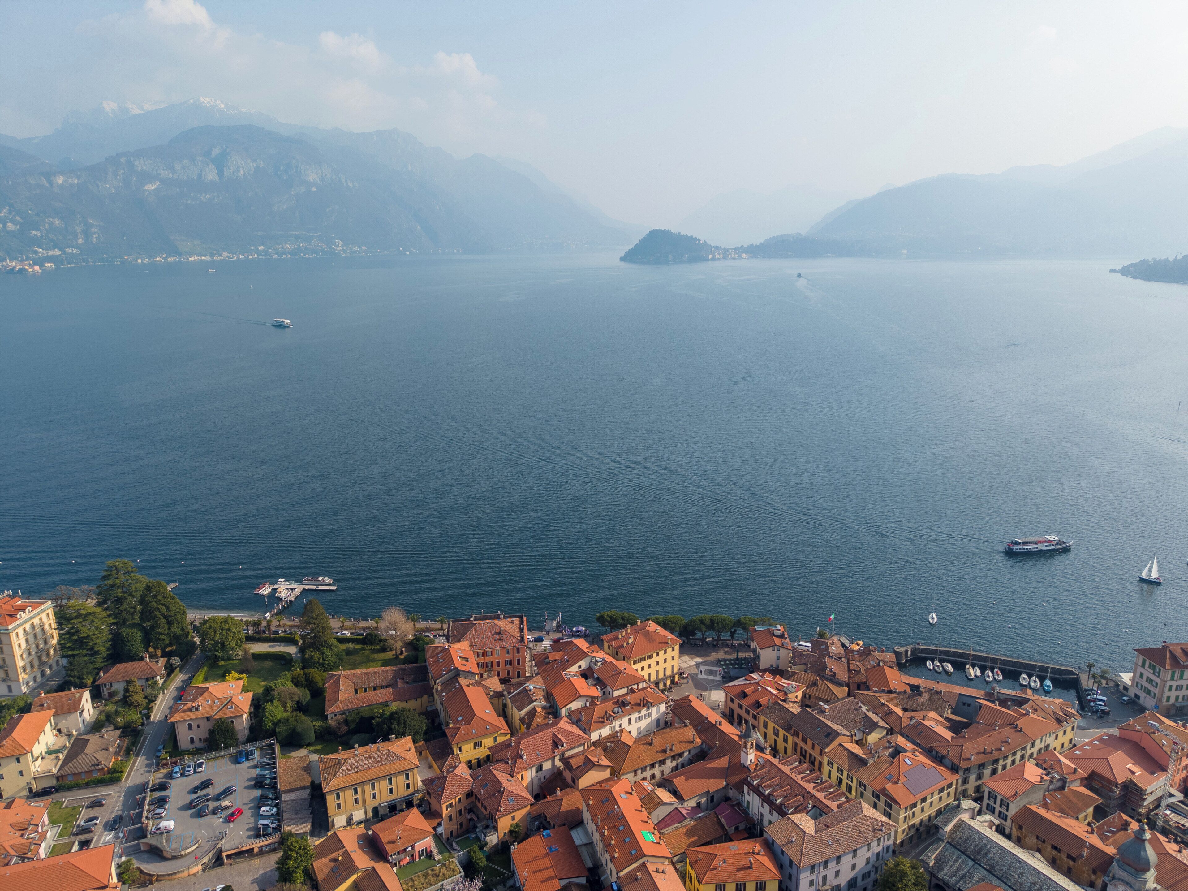 Une ville côtière avec des bâtiments, un port de plaisance et des bateaux sur l’eau.