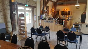 Ambiente rustico con angolo bar, travi in legno e parete in pietra.