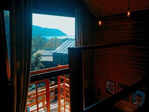 A room with a large window overlooking a mountainous landscape.