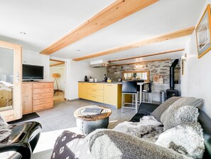 Ein modernes Wohnzimmer mit einer Couch, einem Couchtisch und einem Fernseher.