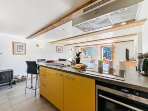 Eine moderne Küche mit gelben Schränken, einer Edelstahl-Spüle und einem eingebauten Backofen.