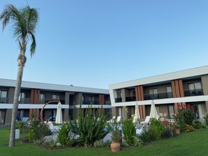 Ein modernes Hotel mit Pool, Außenbereich und üppiger Bepflanzung.