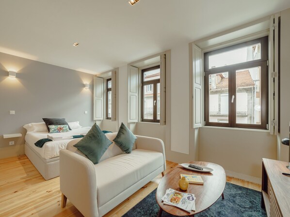 Et moderne hotelværelse med en sofa, et lille bord og en seng.