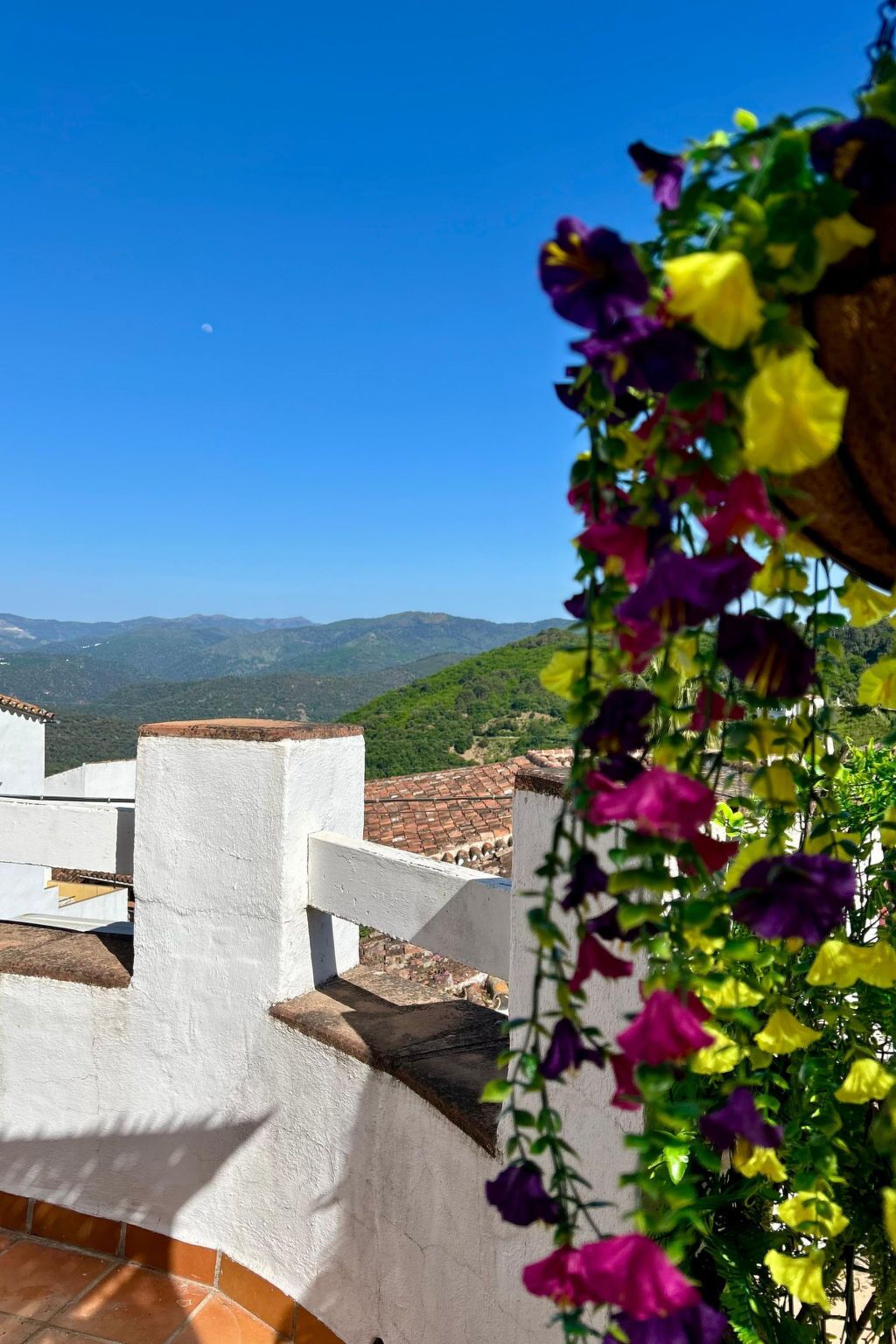Un edificio blanco con vistas a colinas verdes y un cielo despejado.