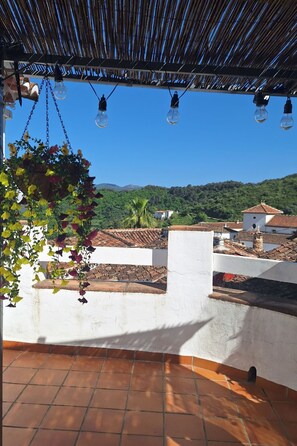 A terrace with hanging plants, a tiled floor, and a view of a hillside. - Casa la Solana by Interhome (Benadalid)