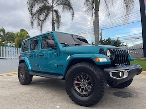 A turquoise Jeep with off-road tires parked on a concrete surface. - Spacious Family Apartment With Pool Access in Santiago (Santiago de los Caballeros)