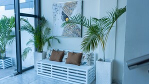 Een modern interieur met een witte bank, een groot raam en potplanten.