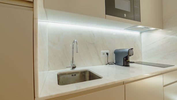 A modern kitchen with a stainless steel sink, a coffee machine, and a built-in oven. - Apartment  by Interhome (Porto)