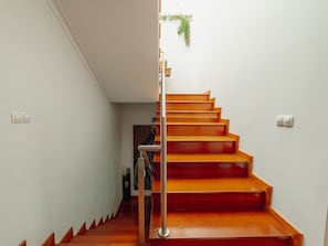 A wooden staircase with a metal handrail leading to a landing. - POOL & CINEMA VILLA by VACATIONY by Interhome (Porto)