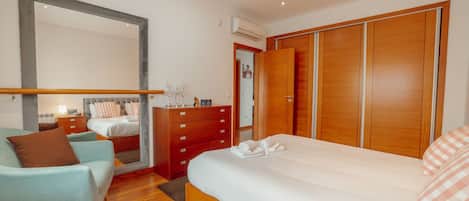 Un dormitorio moderno con una cama grande, un tocador, un armario y un espejo.