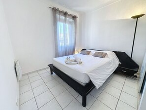 A hotel room with a bed, a bedside table, a lamp, and a window with curtains. - Central 1 bedroom Riouffe 206 2 mins from Palais by Interhome (Cannes)