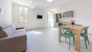 Un appartamento moderno con zona living, un tavolo da pranzo e una cucina.