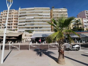 A multi-story hotel with balconies, a palm tree, and outdoor seating areas. - Amazing sea view 2 bedroom front of the beach 303 by Interhome (Cannes)