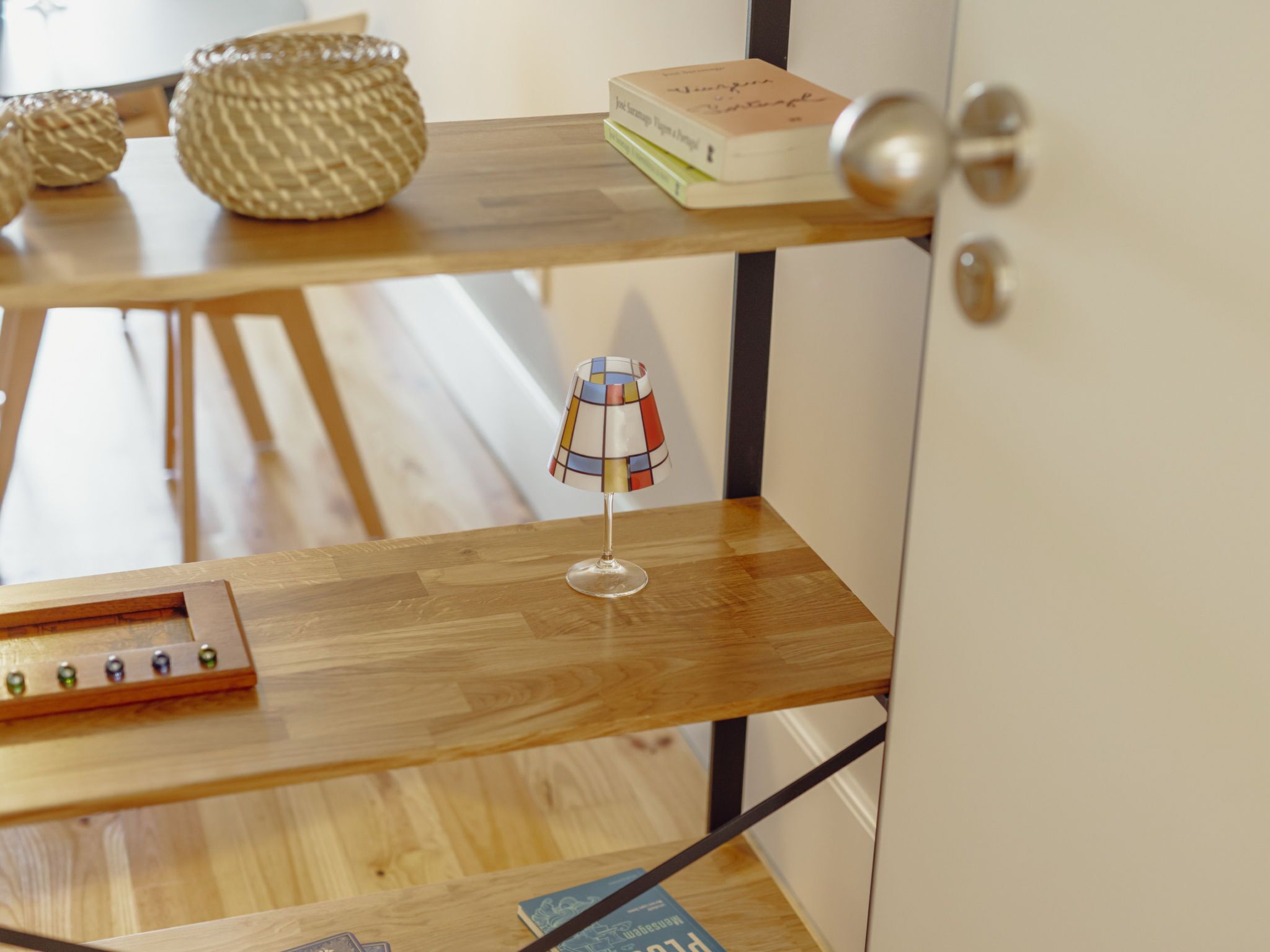 A wooden shelf with a lamp, a book, and decorative items.
