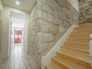A staircase with wooden steps and a stone wall. - Apartment  by Interhome (Porto)