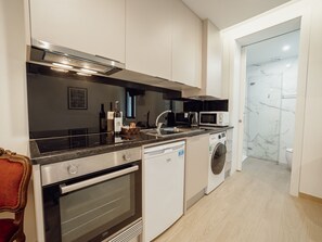 A modern kitchen with a dishwasher, oven, microwave, and a washing machine. - Apartment  by Interhome (Porto)