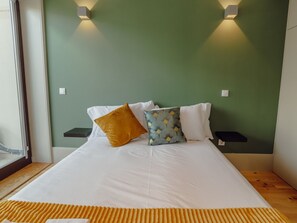 A bed with white bedding, two nightstands, and a green wall with wall-mounted lights. - Apartment  by Interhome (Porto)