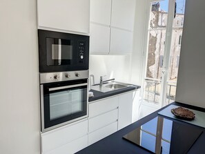 A modern kitchen with a built-in oven, microwave, and a stainless steel sink. - Apartment  by Interhome (Cannes)