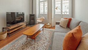 Ett modernt vardagsrum med en tv, en soffa och en öppen spis.