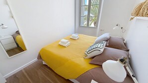 Una camera da letto con un letto, una lampada da comodino, uno specchio e una finestra.
